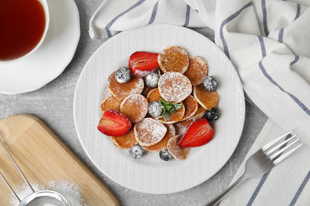 Cereal pancakes with berries served on light gray table, flat layの写真素材