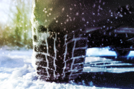 Car with winter tires on snowy road, closeup viewの写真素材