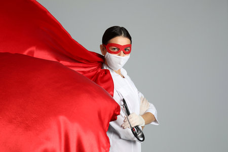 Doctor dressed as superhero posing on white background.の写真素材
