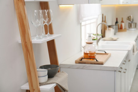 Stylish kitchen room interior with wooden ladder near white wallの写真素材