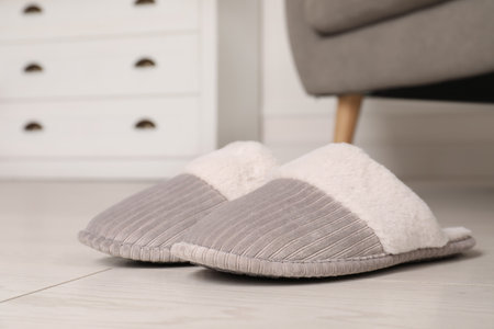 Gray warm slippers on floor in room