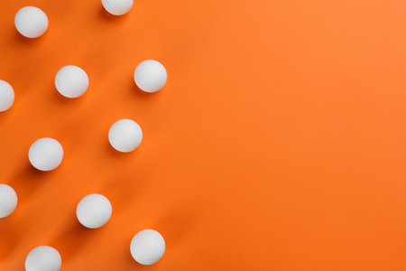 table tennis balls on orange background, flat lay. Space for textの写真素材