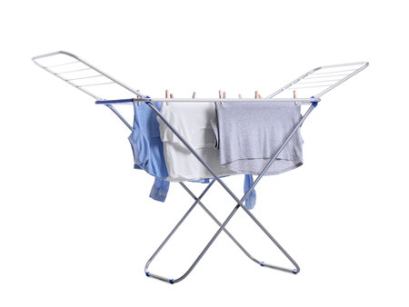 Clean laundry hanging on drying rack against white backgroundの写真素材