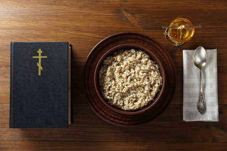 Bible, oatmeal porridge and spoon on wooden table, flat lay. Lent seasonの写真素材