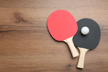 Table tennis rackets and balls on wooden table, flat lay. Space for textの写真素材