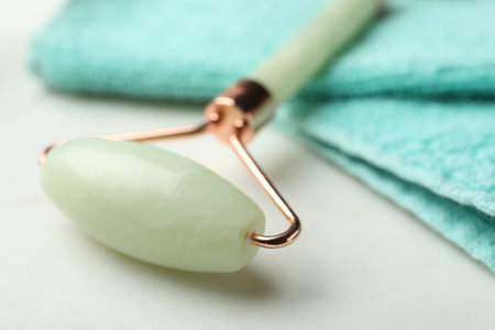 Natural jade face roller and towel on light background, closeupの写真素材