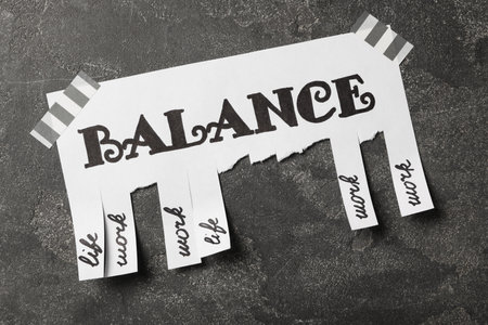 Paper sheet with torn off pieces on gray table, top view. Life work balance conceptの写真素材