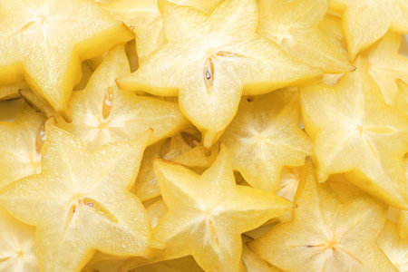 Pile of delicious carambola slices as background, top viewの写真素材