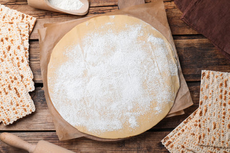Matzos and raw dough on wooden table, flat layの写真素材