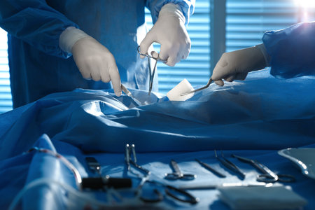 Professional surgeons with instruments performing operation in clinic, closeupの写真素材