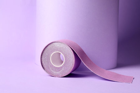 Bright kinesiology tape in roll on lilac backgroundの写真素材