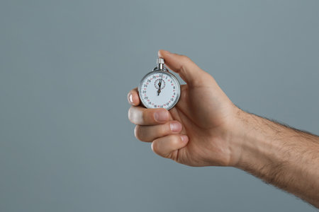 Man holding vintage timer on gray background, closeupの写真素材