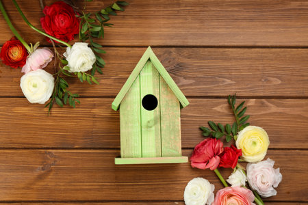 Stylish bird house and fresh eustoma on wooden background, flat layの写真素材