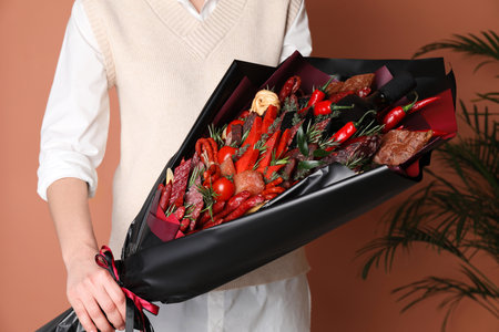 Woman with beautiful food bouquet on brown background, closeupの写真素材