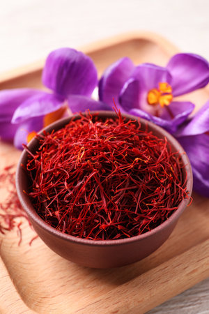 Dried saffron and crocus flowers on wooden tray, closeupの写真素材