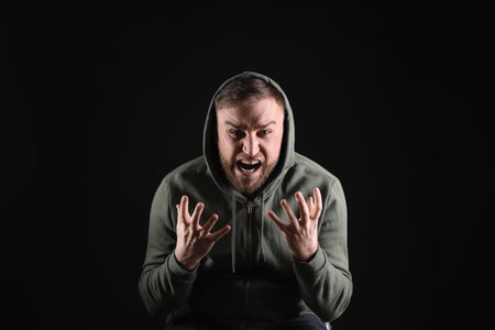 Portrait of emotional young man on black background. Personality conceptの写真素材