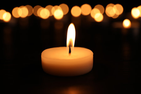 Burning candle on dark surface. memory dayの写真素材