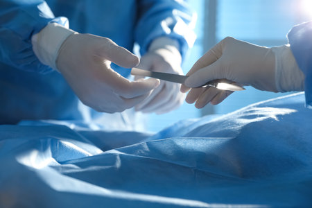 Professional surgeons with instruments performing operation in clinic, closeupの写真素材