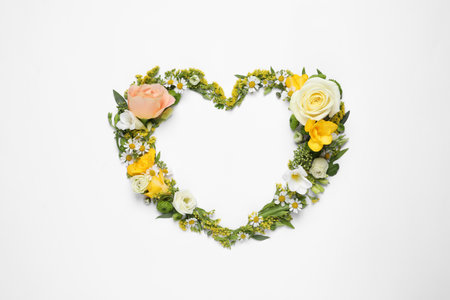 Beautiful heart made of different flowers on white background, top viewの写真素材