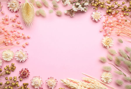 Frame of beautiful dried flowers on light pink background, flat lay. Space for textの写真素材