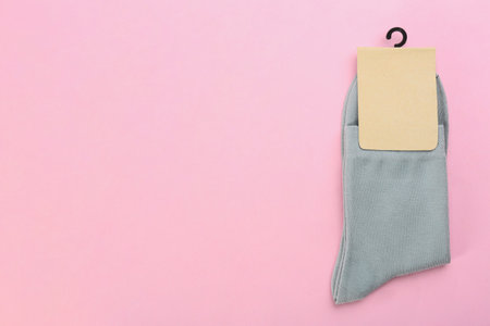 Pair of gray cotton socks on light pink background, top view. Space for textの写真素材