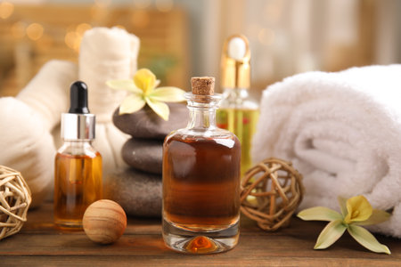 Beautiful spa composition with essential oil on wooden table against blurred lightsの写真素材