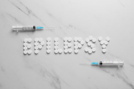 Word Epilepsy made of pills and syringes on white marble table, flat layの写真素材