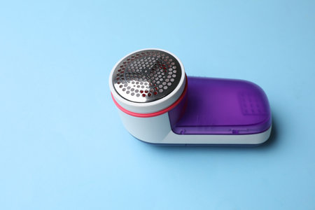 Modern fabric shaver on light blue backgroundの写真素材
