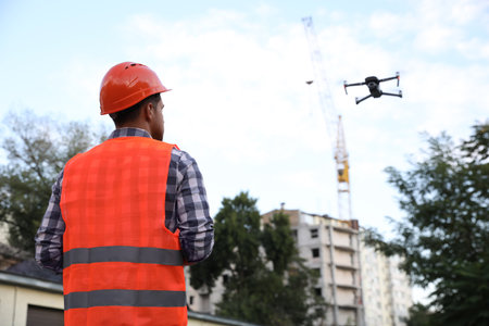 Builder operating drone with remote control at construction site. aerial photographyの写真素材