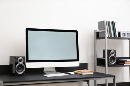 Modern computer with audio speakers on table indoorsの写真素材
