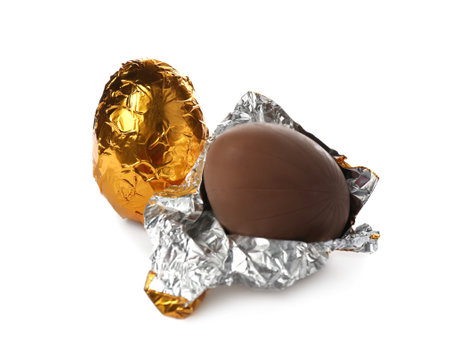 Chocolate eggs in golden foil on white backgroundの写真素材