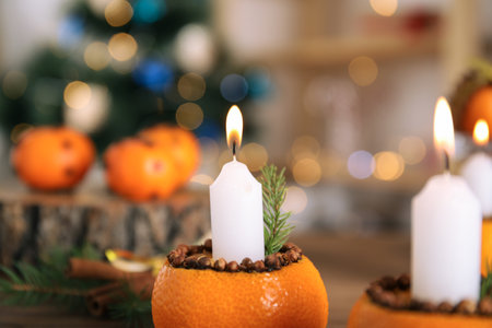 Burning candle in tangerine peel as holder against blurred background, closeupの写真素材