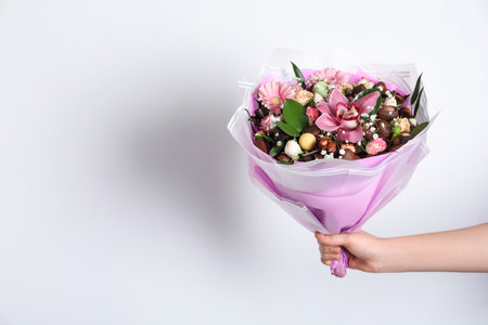 Woman with beautiful edible bouquet on white background, closeup. Space for textの写真素材