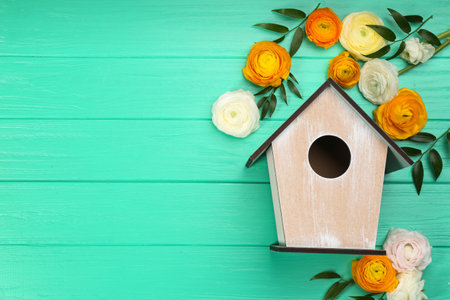 Stylish bird house and fresh eustomas on turquoise wooden background, flat lay. Space for textの写真素材