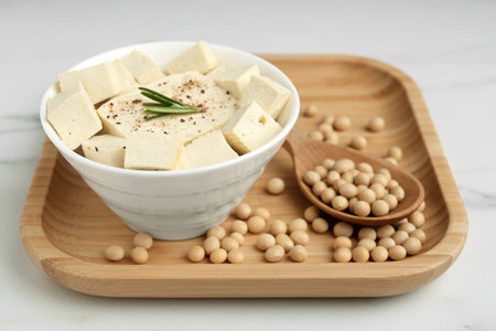 Pieces of delicious tofu with rosemary and soy on white wooden tableの写真素材