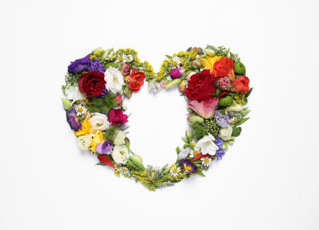Beautiful heart made of different flowers on white background, top viewの写真素材
