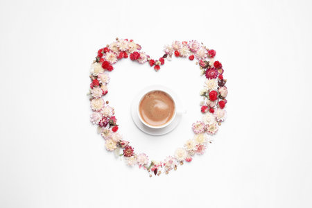 Beautiful heart shaped floral composition with cup of coffee on light background, flat layの写真素材