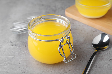 Glass jar of Ghee butter on gray table, closeupの写真素材