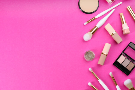 Flat lay composition with makeup brushes on bright pink background, space for textの写真素材