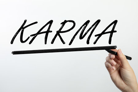 Woman writing word KARMA on glass against white background, closeupの写真素材