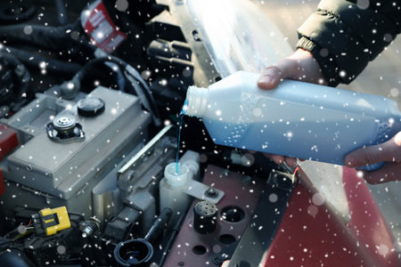 Man filling car radiator with antifreeze outdoors, closeupの写真素材