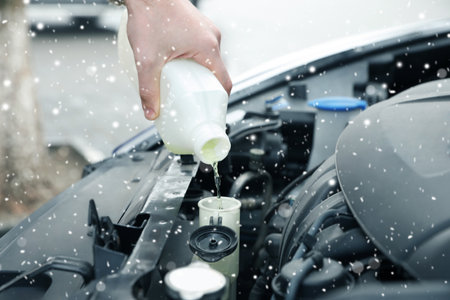 Man filling car radiator with antifreeze outdoors, closeupの写真素材