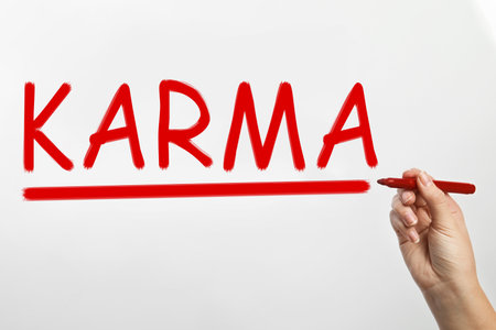 Woman writing word KARMA on glass against white background, closeupの写真素材