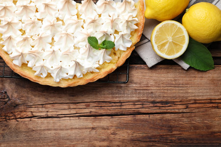Flat lay composition with delicious lemon meringue pie on wooden table. Space for textの写真素材
