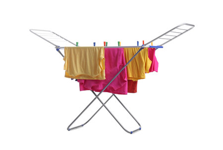 Clean laundry hanging on drying rack against white backgroundの写真素材