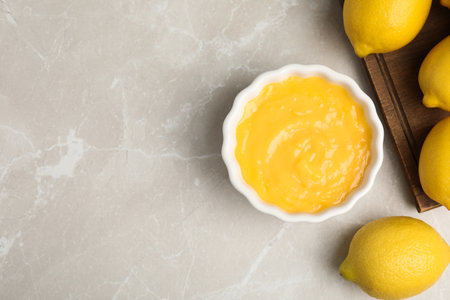 Delicious lemon curd and fresh fruits on light gray marble table, flat lay. Space for textの写真素材