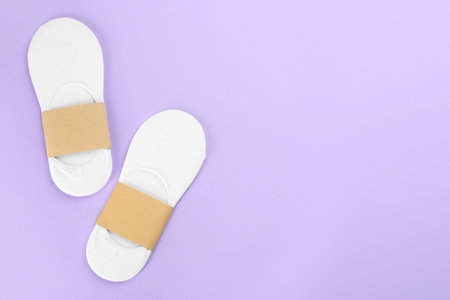 Soft cotton socks on lilac background, flat lay. Space for textの写真素材