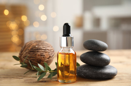 Beautiful spa composition with essential oil on wooden table against blurred lightsの写真素材