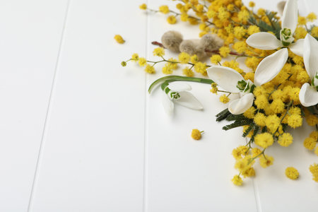 Beautiful floral composition with mimosa flowers on white wooden background, closeup. Space for textの写真素材