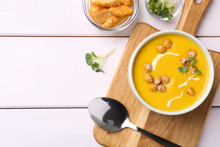 Delicious cream soup with chickpeas on white wooden table, flat lay. Space for textの写真素材